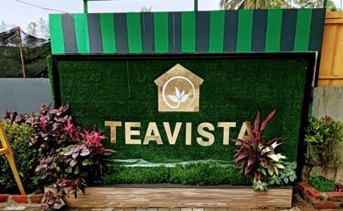 a sign that reads teakiste on a green wall at Tea vista holiday home in Kalpetta