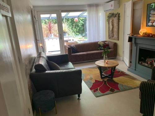 a living room with a couch and a fireplace at Romantisch Wellness Appartement met privé Hottub Sauna Gamesroom in Den Ham
