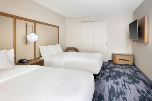a hotel room with two beds and a flat screen tv at Fairfield by Marriott Mission Viejo Orange County in Mission Viejo