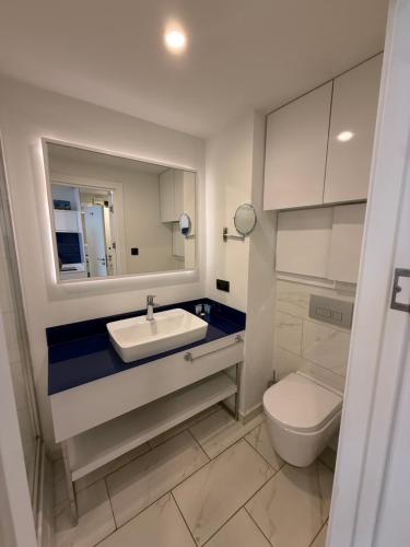 a bathroom with a sink and a toilet and a mirror at New orbi city Towers in Batumi