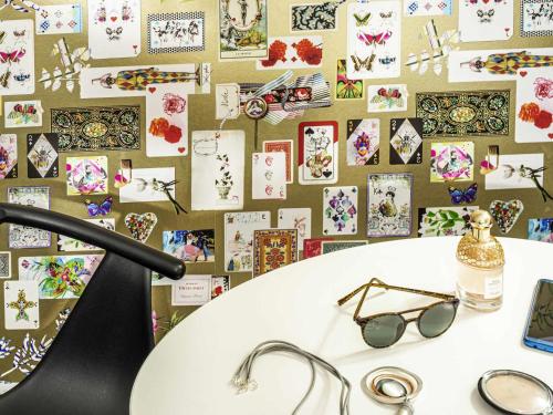 a table with glasses and a wall of cards at Ibis Styles Reims Centre in Reims
