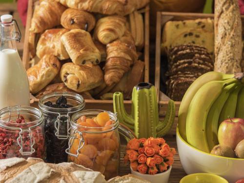 a table with a bunch of bread and other foods at Ibis Styles Reims Centre in Reims