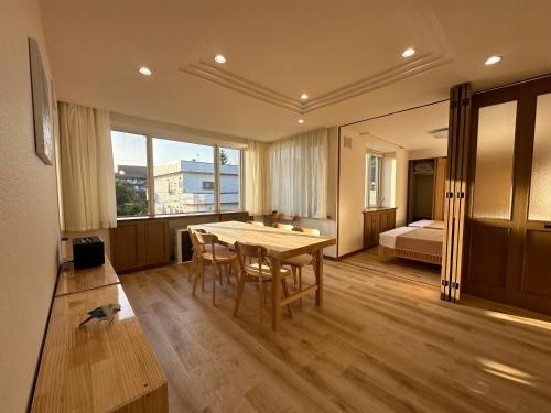 a room with a table and chairs and a bed at Teine blue house手稻藍房子 in Sapporo