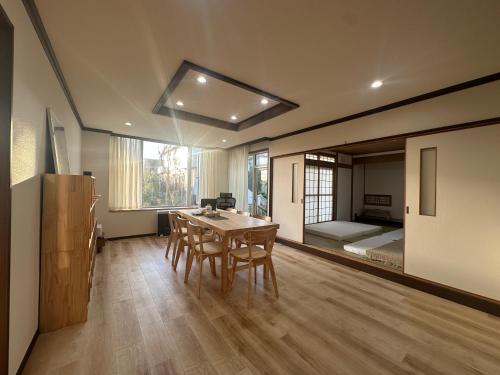 a room with a table and chairs and a bedroom at Teine blue house手稻藍房子 in Sapporo
