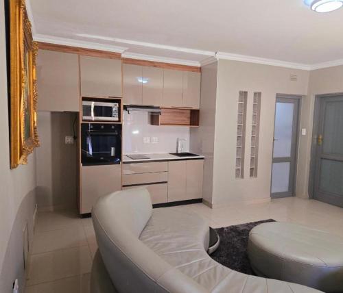 a living room with a couch and a kitchen at Sandown Suites and Conference Centre in Johannesburg