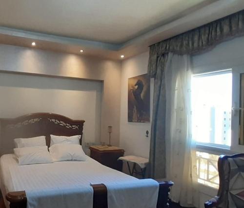 une chambre avec un grand lit et une fenêtre dans l'établissement Luxury 3 bed room apartment in rehab october city compound - modern open view luxury stay, à ‘Ezbet `Abd el-Ḥamîd