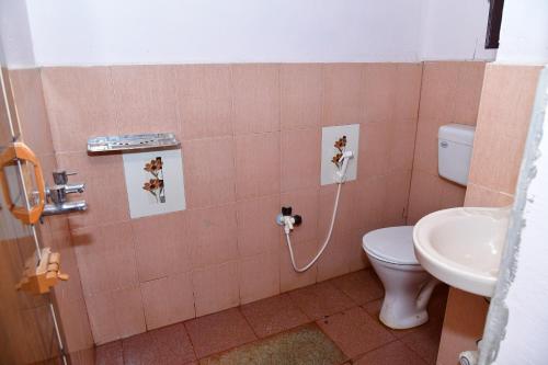 a bathroom with a toilet and a sink at SugarLeaf Homestay - Home Food & Near to Tourist Places in Sakleshpur