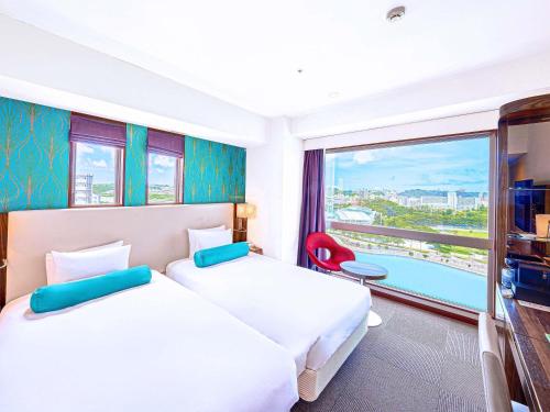 two beds in a hotel room with a view at Mercure Okinawa Naha in Naha