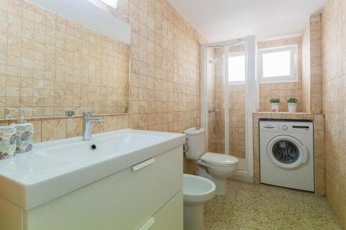 a bathroom with a sink and a washing machine at Cozy Apartment in Salinetas Beach. in Salinetas