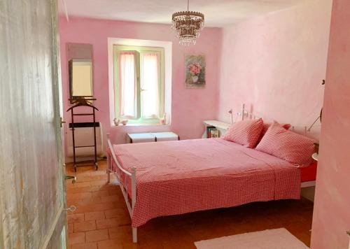 a pink bedroom with a pink bed and a window at Country House Ca di siro in Gazola