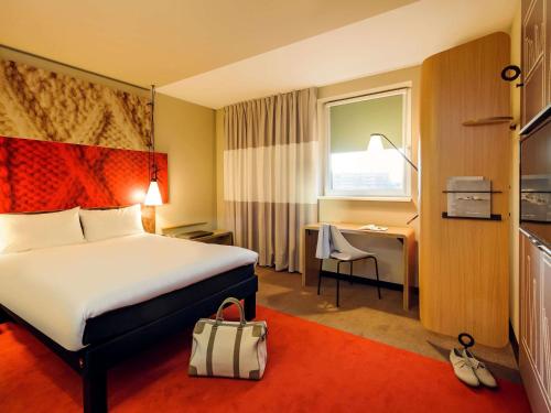 a hotel room with a bed and a desk at Ibis Hamburg City in Hamburg