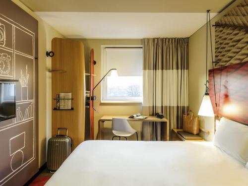 a hotel room with a bed and a desk at Ibis Hamburg City in Hamburg