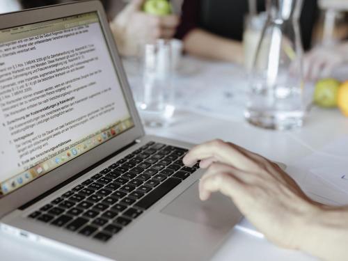 a person typing on a laptop computer on a table at Ibis Hamburg City in Hamburg
