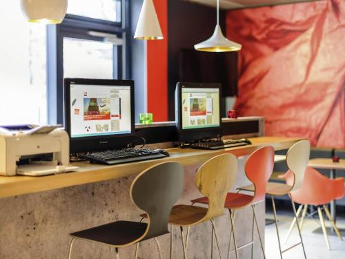 a desk with two computer monitors on top of it at Ibis Hamburg City in Hamburg