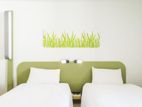 two beds sitting next to each other in a room at ibis budget Hamburg City in Hamburg
