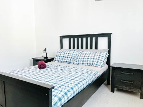 a bed with a blue and white checkered comforter and pillows at Remarkable 5-Bed Apartment in Kilamba - Luanda in Luanda