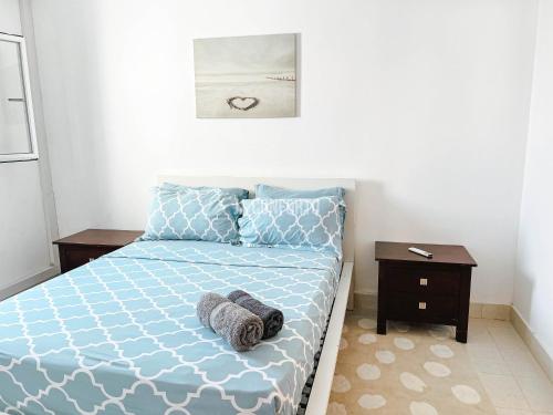 a bedroom with a blue bed with towels on it at Remarkable 5-Bed Apartment in Kilamba - Luanda in Luanda