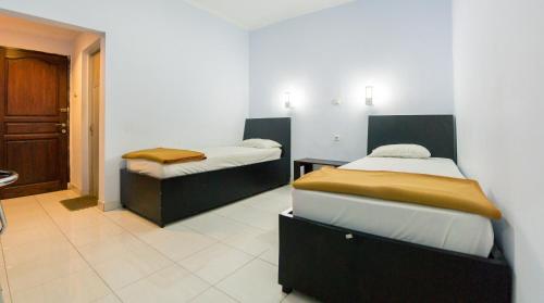 een kamer met 2 bedden en een hal bij Hotel Ledetadu in Kupang