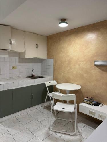a kitchen with a table and a table and chairs at Frank Lloyd Apartelle in Manila