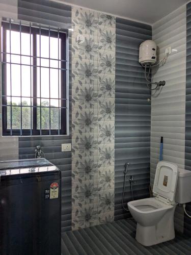 Un baño con inodoro, lavabo y ventana. en Shivkrupa Apartments, en Arambol