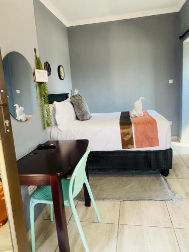 a bedroom with a bed and a desk and a table at Minnestay Guest House in Palatswe