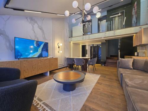a living room with a couch and a tv and a table at Apartments Lura in Peje