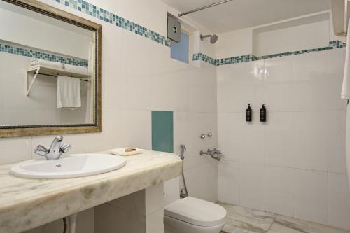 a bathroom with a sink and a toilet and a shower at Rampratap Palace by Fateh Collection in Udaipur