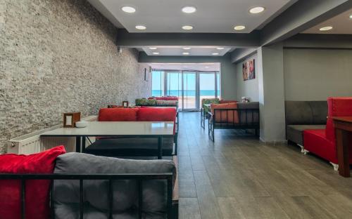 a waiting room with red chairs and a table at Airport Black Sea Hotel & Restaurant in Arnavutköy