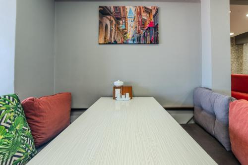 a white table in a room with two couches at Airport Black Sea Hotel & Restaurant in Arnavutköy