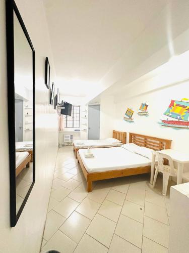 a room with two beds and a mirror at Frank Lloyd Apartelle in Manila