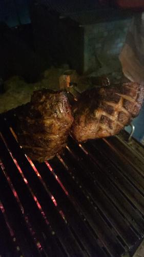 a piece of meat is cooking on a grill at Dpto Amplio, TV75in, Cochera, Céntrico y BBQ in Huancayo