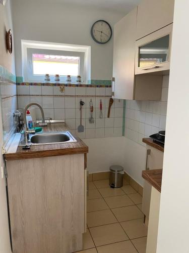 a kitchen with a sink and a clock on the wall at Müllers Ferienhäuser Gunaras & Harmonie in Gunaras in Dombóvár