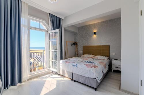 a bedroom with a bed and a large window at Airport Black Sea Hotel & Restaurant in Arnavutköy
