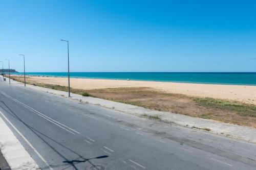 an empty road next to a beach with the ocean at Airport Black Sea Hotel & Restaurant in Arnavutköy