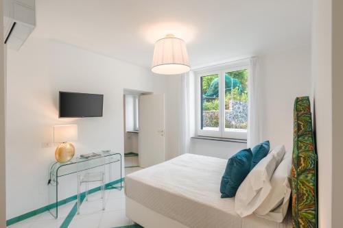 a white bedroom with a bed and a window at Torre Paradiso in Minori