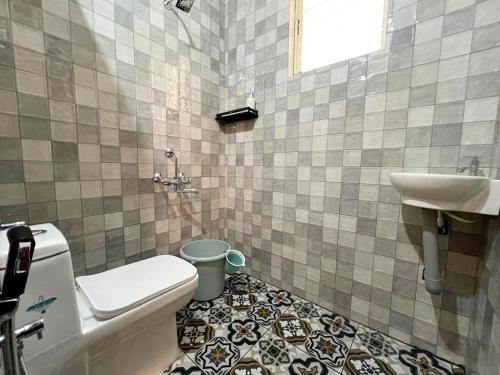 a bathroom with a toilet and a sink at Athiratha Living in Malpe