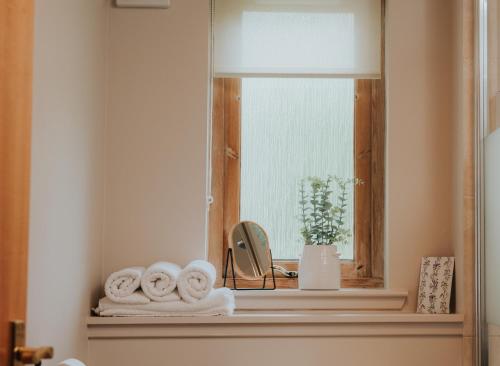 Una ventana con toallas en un estante en un baño. en Spacious Flat with Parking Great Inverness Base, en Inverness