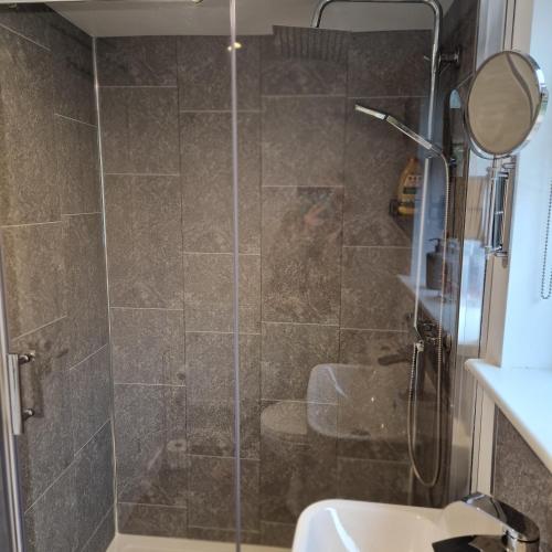 a shower with a glass door in a bathroom at Welcoming ensuite bedroom in Wolverhampton