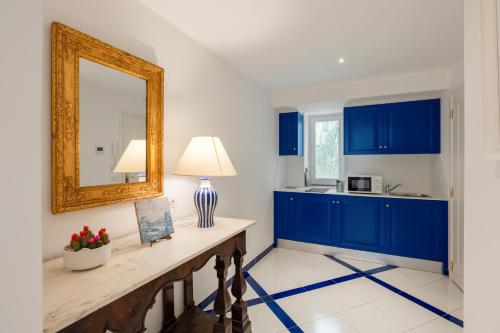 a kitchen with blue cabinets and a mirror at Torre Paradiso in Minori