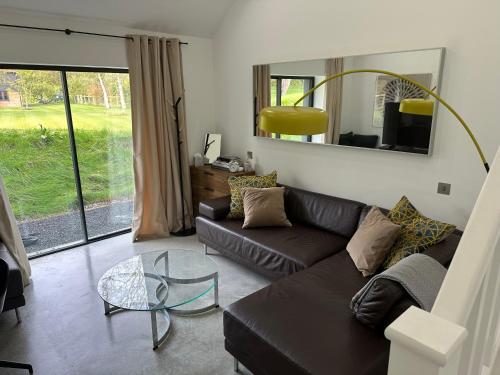 a living room with a couch and a glass table at Contemporary modern barn in Folkestone