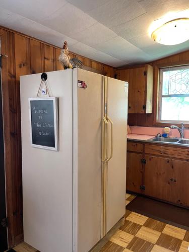 a refrigerator in a kitchen with a sign on it at The Lily Pad in Pinckney