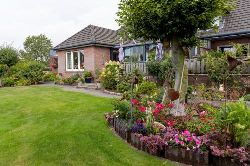 a garden in front of a house with flowers at Ferienwohnungen Schoofs in Kalkar