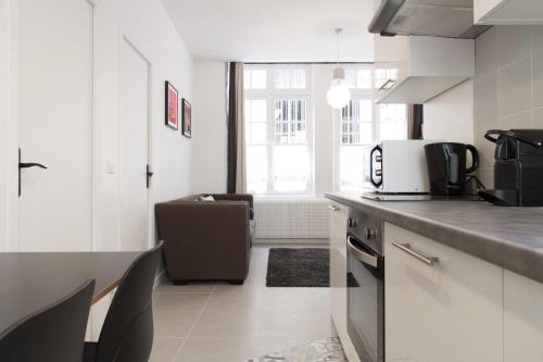a kitchen with white cabinets and a counter top at BnBNova - 2BR - St Germain des Prés in Paris