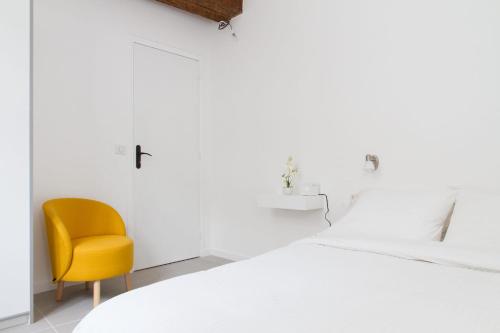 a bedroom with a bed and a yellow chair at BnBNova - 2BR - St Germain des Prés in Paris