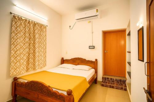 a small bedroom with a bed and a window at LeBeach Villa, Luxurious Stay Opposite Auroville Beach, ECR Road in Kuilapayam