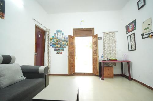 a living room with a couch and a door at LeBeach Villa, Luxurious Stay Opposite Auroville Beach, ECR Road in Kuilapayam