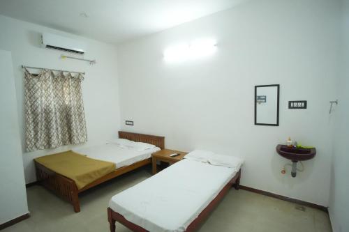 a room with two beds and a window at LeBeach Villa, Luxurious Stay Opposite Auroville Beach, ECR Road in Kuilapayam