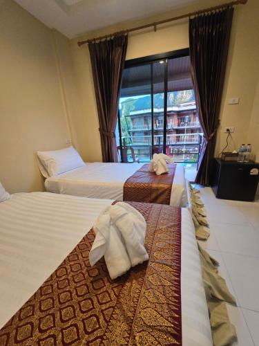 a hotel room with two beds and a window at Ao Nang 9 Rooms and Stay in Ao Nang 