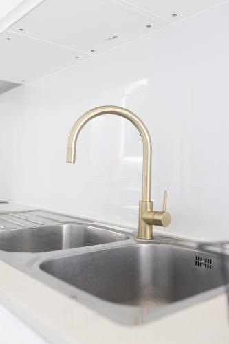 a stainless steel sink in a white kitchen at Zen Escape Guest House " Location 1" - Three listings - Romantic Escape, Cozy Delight, Oasis Suite in Brisbane