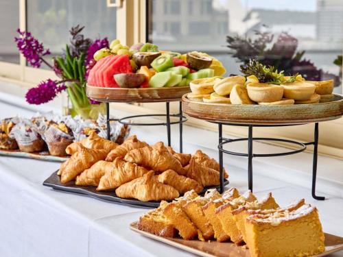 a table topped with different types of bread and pastries at The Sebel Quay West Suites Sydney in Sydney